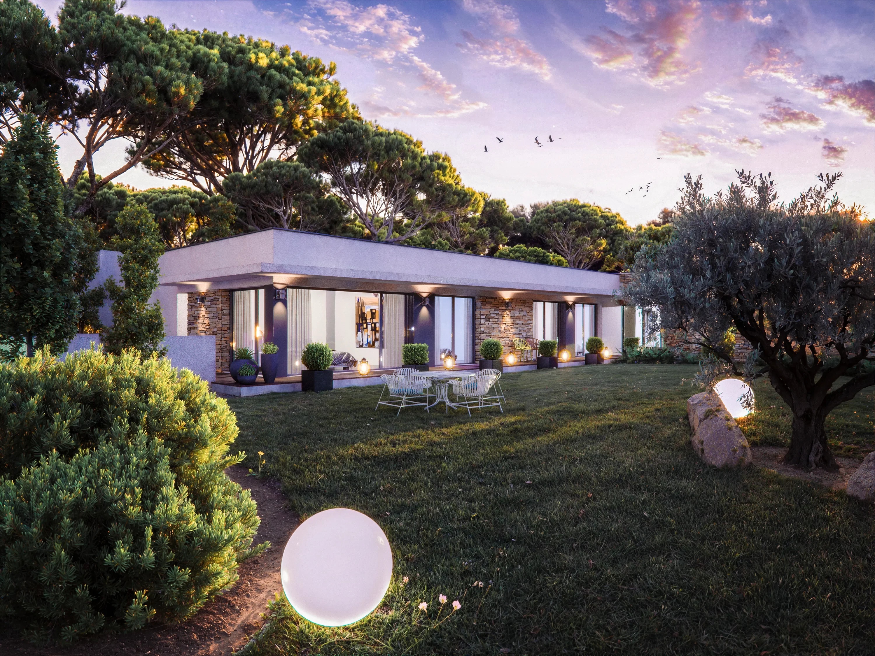 Villa à La Colle-sur-Loup pour Lewis Morgan : façade éclairée au crépuscule, pins et oliviers dans le jardin.